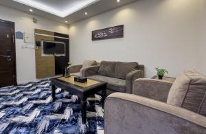 a living room with a couch and a table at أبهى حياه للشقق المخدومة - إقتصادي in Abha