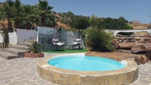 a large pool in a yard with a stone patio at Bed & Breakfast Casa Ceratonia in Alora