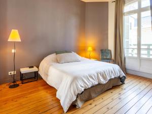 a bedroom with a large white bed and a window at Holiday Home Victor Hugo by Interhome in Deauville