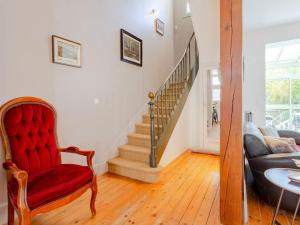 a living room with a red chair and stairs at Holiday Home Victor Hugo by Interhome in Deauville