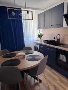 eine Küche mit einem Holztisch mit Stühlen und einem Waschbecken in der Unterkunft Ianis Home in Hunedoara