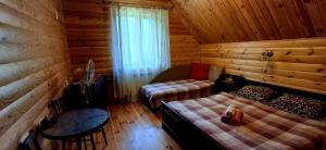 a bedroom with a bed and a couch in a cabin at Садиба Орисин Явір Orysyn Yavir in Svityazʼ