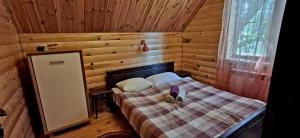 a bedroom with a bed in a wooden cabin at Садиба Орисин Явір Orysyn Yavir in Svityazʼ