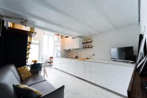 a living room with a couch and a kitchen at Metro M1 - Stylish Loft Retreat in Sesto San Giovanni