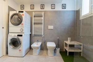 a bathroom with a washing machine and a toilet at Metro M1 - Stylish Loft Retreat in Sesto San Giovanni +40 photos