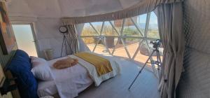 a room with a bed in a tent with a window at Dome Bally Kampia in Kambiá
