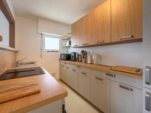 a kitchen with wooden cabinets and a counter top at Apartment Ty Bara by Interhome in Carnac