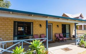 une terrasse avec des chaises et des tables dans une maison dans l'établissement Kindlewood Cottage, à Esperance