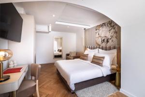 a bedroom with a large white bed and a desk at Boutique Hotel Mauro in Poreč