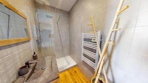 a bathroom with a shower and a bath tub at Grand appartement avec piscine in Clermont-Ferrand