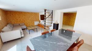 a living room with a table and a couch at Grand appartement avec piscine in Clermont-Ferrand