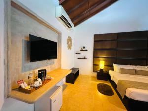 a bedroom with a bed and a television on a wall at Rankendiya Resort - Habarana in Habarana