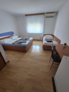 a bedroom with two beds and a desk and a table at Guesthouse Koprivec in Ljubljana