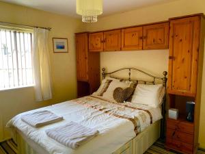 a bedroom with a large bed with wooden cabinets at Northern homestay between High Peak & Manchester in Hadfield