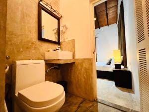 a bathroom with a toilet and a sink and a mirror at Rankendiya Resort - Habarana in Habarana +48 photos