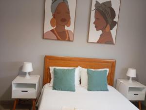a bedroom with a bed with two pictures on the wall at House da Didy in São João da Pesqueira