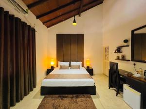 a bedroom with a bed and a desk with two lamps at Rankendiya Resort - Habarana in Habarana
