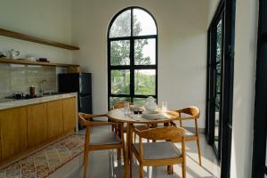 a dining room with a table and chairs and a kitchen at Villa Alaya No 4 in Cemagi