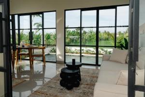 a living room with a white couch and a table at Villa Alaya No 4 in Cemagi