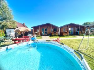a swimming pool in the yard of a house at Osada Familia in Sarbinowo