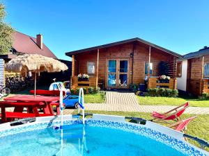 a swimming pool in front of a house at Osada Familia in Sarbinowo