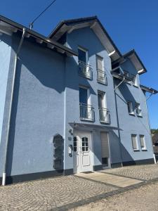 a blue building with a white door and balcony at Ferienwohnung Kornotti in Wimbach