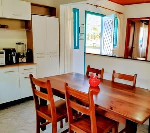 a kitchen with a wooden table with two chairs and a table at Vila de Casas de Campo Rústica e Aconchegante na Mata Atlântica in Juquitiba