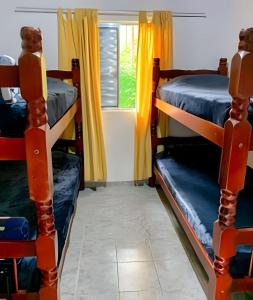a room with two bunk beds and a window at Vila de Casas de Campo Rústica e Aconchegante na Mata Atlântica in Juquitiba +35 photos