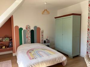 a bedroom with a bed with a colorful wall at Maison de Campagne in Saint-Mars-dʼOutillé