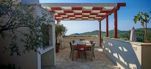 a patio with a table and chairs on a balcony at Villa Smoquizza in Smokvica