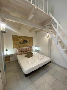 een slaapkamer met een groot wit bed en een trap bij La Casa dei Venti in Gallipoli