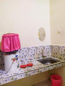 a bathroom with a sink and a toilet with a pink bag on it at KB HOMESTAY Mongkonai in Kebido +3 photos