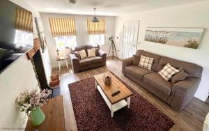 a living room with a couch and a coffee table at Gingerbread Cottage - Part of the The Bay Filey Holiday Village with pool, gym and direct beach access, pub, restaurant, tennis and meadows walks in Filey