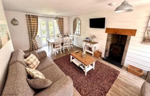 a living room with a couch and a fireplace at Gingerbread Cottage - Part of the The Bay Filey Holiday Village with pool, gym and direct beach access, pub, restaurant, tennis and meadows walks in Filey