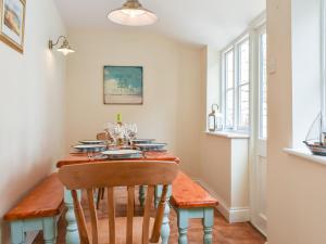 a dining room with a wooden table and chairs at Pilchard Cottage in Scarborough