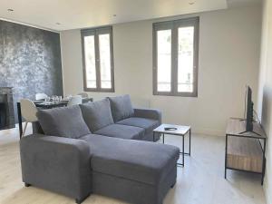 a living room with a couch and a television at Le Briand in Tulle