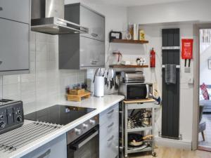 a kitchen with a stove and a refrigerator at The Old Telephone Exchange in Rothbury