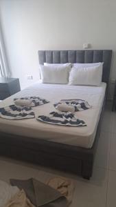 a bed with two pillows on top of it at Modern Cosy Holiday Apartment in Paralimni +5 photos
