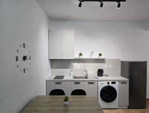 a white kitchen with a sink and a dishwasher at Odi Apartments in Durrës