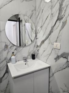 a bathroom with a white sink and a mirror at Odi Apartments in Durrës