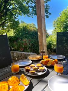 a table topped with plates of food and orange juice at Charming little house with garden, stunning view in Fayence