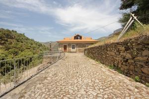 a stone road leading to a house on a hill at Casa Do Riacho - Douro in Armamar