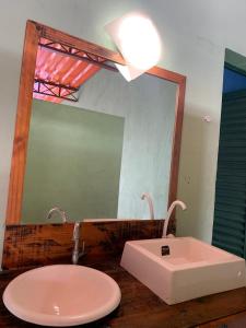 une salle de bain avec un lavabo et un miroir dans l'établissement Espaço Paulista lazer, à Monte Mor