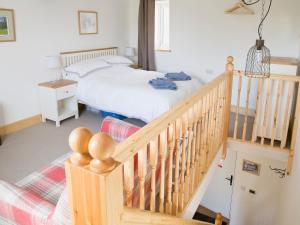 um quarto com uma cama e uma escada de madeira em Riverbank Cottage em Kirkby Stephen