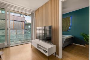 Una sala de estar con un televisor de pantalla plana en una pared. en Seaside Apartment with Central Location in Oslo City Center, en Oslo