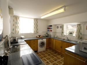 a kitchen with a washer and a washing machine at Chyandaunce in Penzance +3 photos