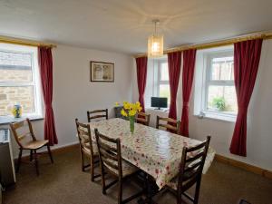 a dining room with a table with flowers on it at Chyandaunce in Penzance