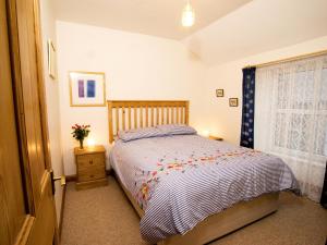 a bedroom with a bed and a window at Chyandaunce in Penzance