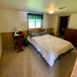 a bedroom with a large bed and a window at Sandy Lake Retreat in Toivola