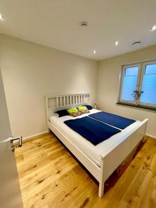 Un dormitorio con una gran cama blanca con sábanas azules. en Moderne gemütliche Wohnung - zentral und naturnah, en Rimbach